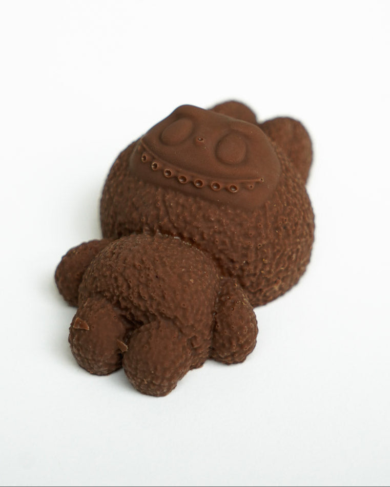 Chocolate Labubu figure lying flat on a white background, showcasing texture and detail